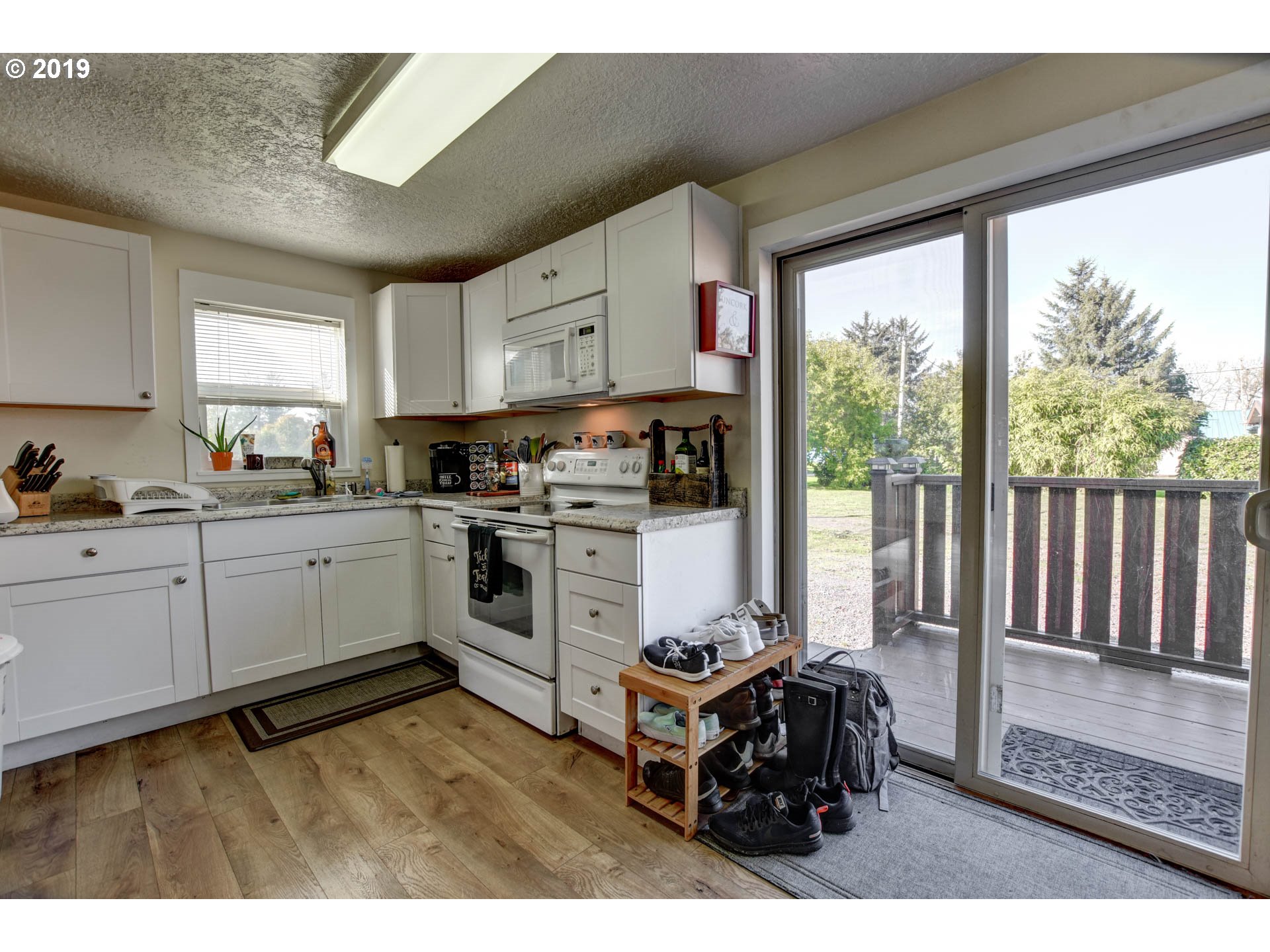 92411 Carnegie Road Astoria, OR 97103 - Photo 10 of 23 a kitchen with stove a sink and white cabinets with wooden floor