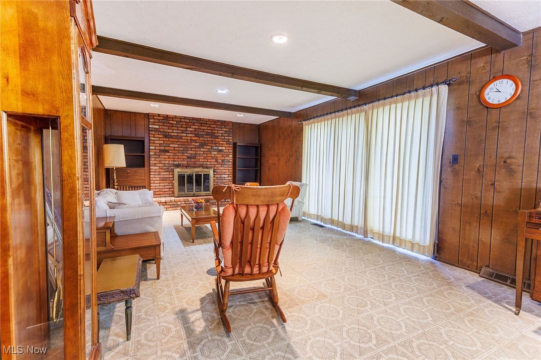 966 Brainard Road Cleveland, OH 44143 - Photo 19 of 50 Living room with beam ceiling, wooden walls, and a fireplace