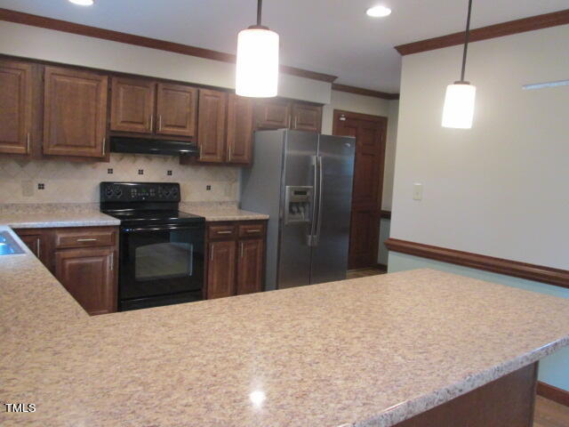200 Raindrop Court Raleigh, NC 27615 - Photo 23 of 61 a kitchen with stainless steel appliances granite countertop a stove a refrigerator and a sink with wooden cabinets