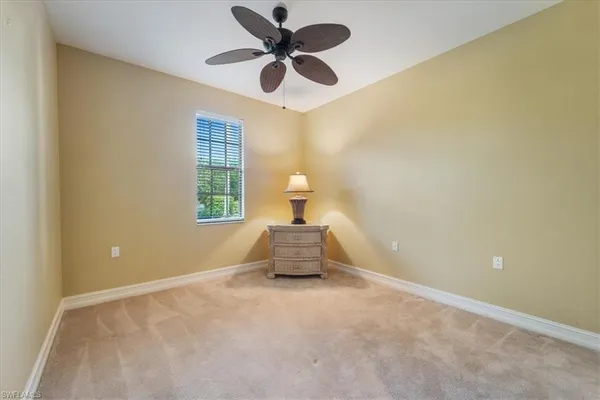 a view of a hallway to a room and a chandelier fan