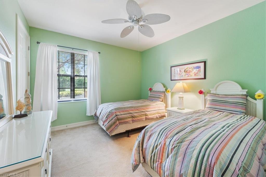 9091 Covina Drive South, Unit 6904 Naples, FL 34113 - Photo 34 of 46 a bedroom with two beds and a chandelier