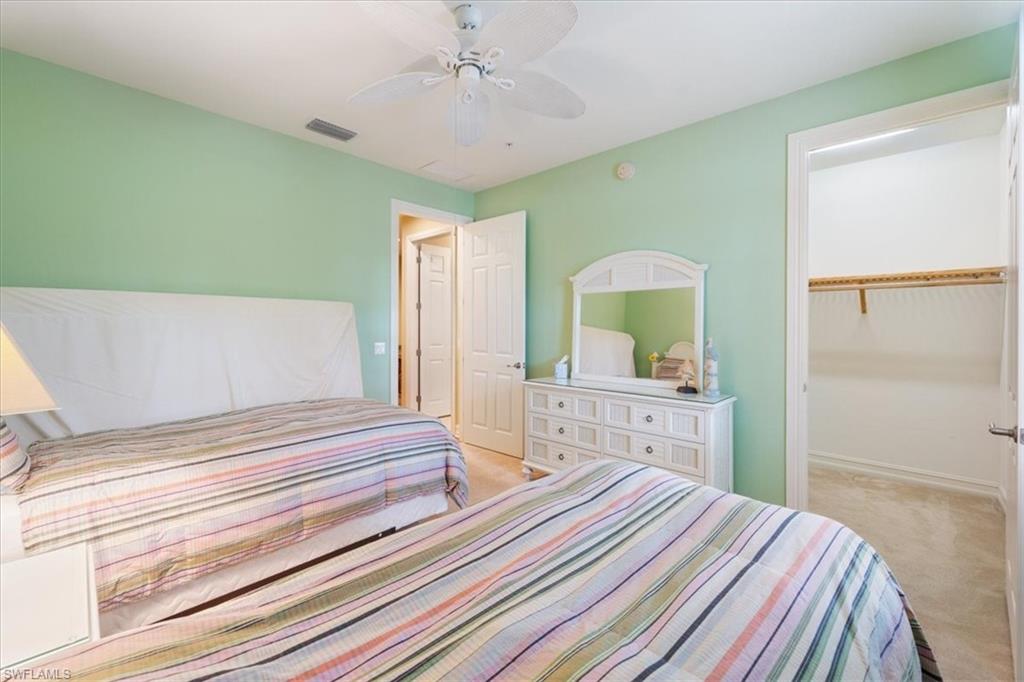 9091 Covina Drive South, Unit 6904 Naples, FL 34113 - Photo 35 of 46 a bedroom with a bed and a chandelier