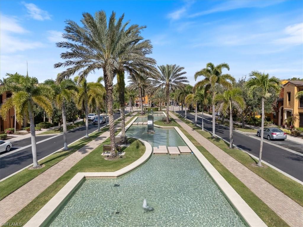 9091 Covina Drive South, Unit 6904 Naples, FL 34113 - Photo 40 of 46 a view of a swimming pool with a lounge chair and palm trees