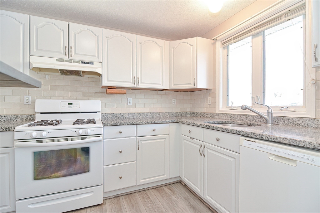 2743 Cranberry Highway, Unit 2D Wareham, MA 02571 - Photo 11 of 37 a kitchen with granite countertop white cabinets and white appliances