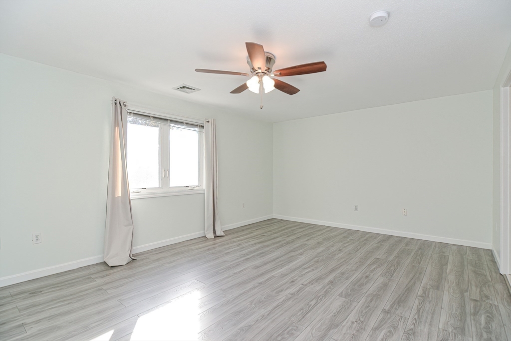 2743 Cranberry Highway, Unit 2D Wareham, MA 02571 - Photo 24 of 37 an empty room with wooden floor ceiling fan and windows