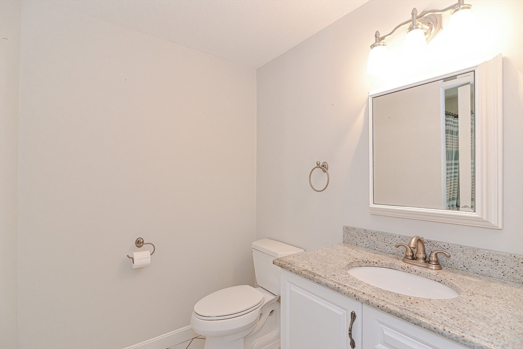 2743 Cranberry Highway, Unit 2D Wareham, MA 02571 - Photo 28 of 37 a bathroom with a granite countertop sink a mirror and a toilet