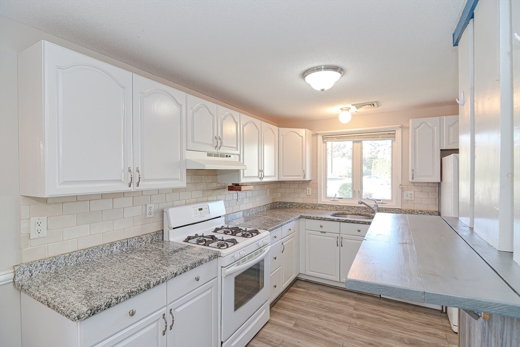 2743 Cranberry Highway, Unit 2D Wareham, MA 02571 - Photo 9 of 37 a kitchen with granite countertop a sink cabinets and window