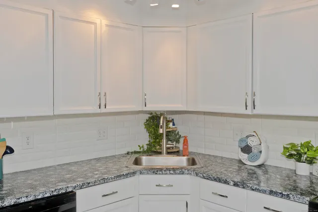 a kitchen with granite countertop white cabinets and a granite counter