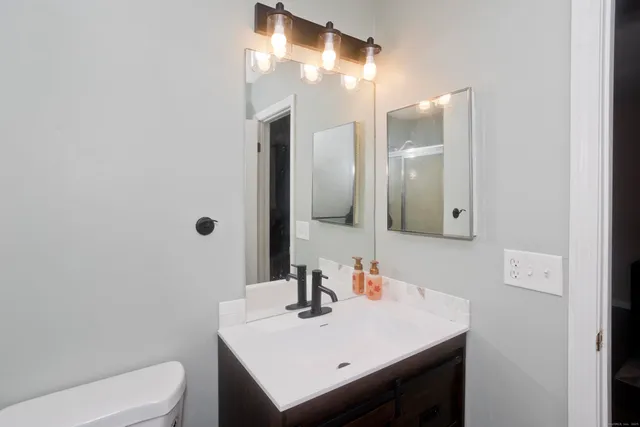a bathroom with a sink toilet and mirror