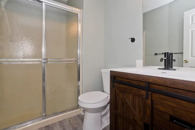 a bathroom with a sink a toilet and shower