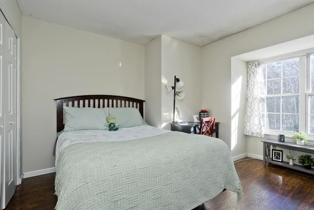 a bedroom with a bed and a large window
