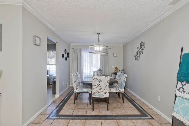 a dining room with wooden floor and a rug