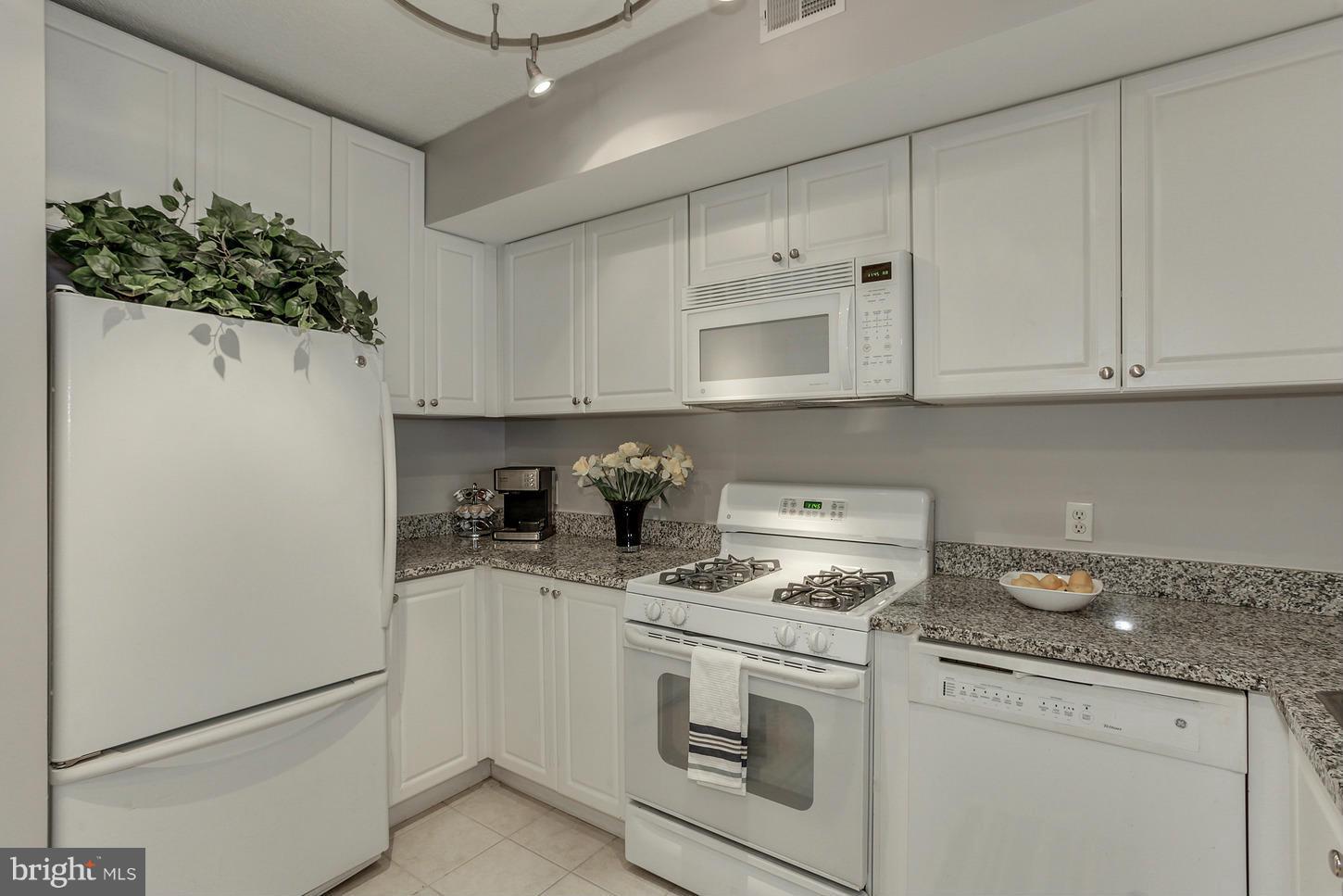851 North Glebe Road, Unit 1010 Arlington, VA 22203 - Photo 8 of 30 a kitchen with stainless steel appliances white cabinets and a stove top oven