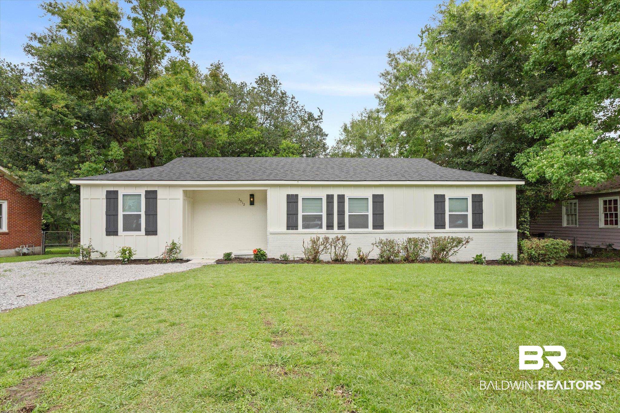 3512 Spring Hill Avenue Mobile, AL 36608 - Photo 1 of 20 Single story home featuring a front yard, brick siding, board and batten siding, and roof with shingles