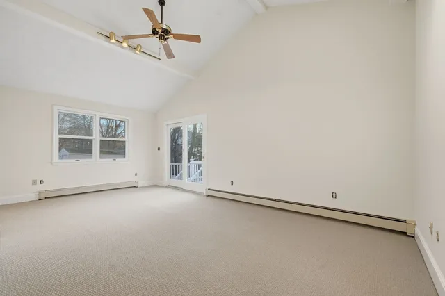 an empty room with windows and ceiling fan