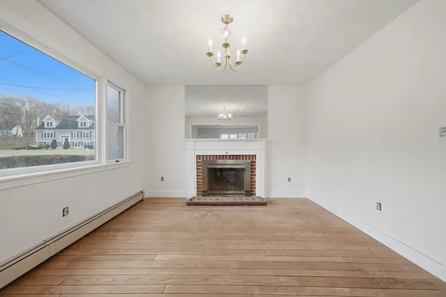 a view of an empty room with a window and a fireplace