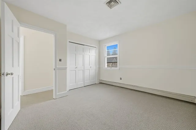 an empty room with chandelier fan and windows