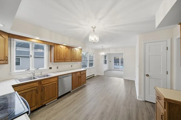 a large kitchen with a lot of counter space and wooden floor
