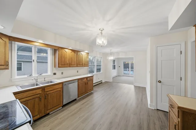 a large kitchen with a lot of counter space and wooden floor