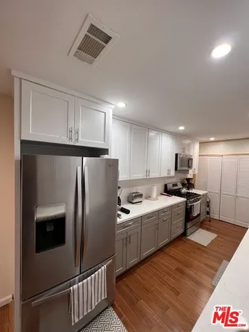 a kitchen with stainless steel appliances granite countertop a refrigerator sink and stove