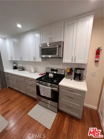 a kitchen with stainless steel appliances granite countertop a stove a sink and a microwave