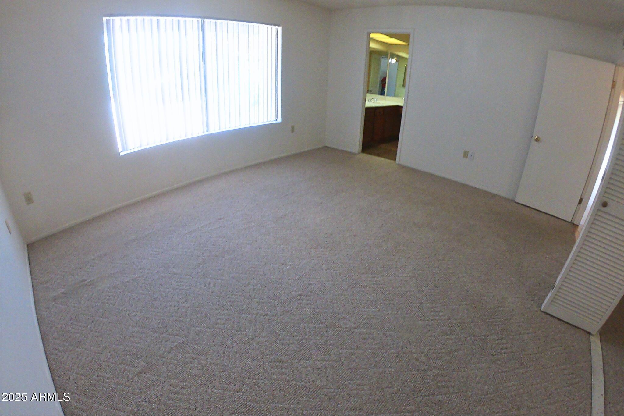 828 East Junction Street, Unit 832 Apache Junction, AZ 85119 - Photo 11 of 17 an empty room with a window and fireplace
