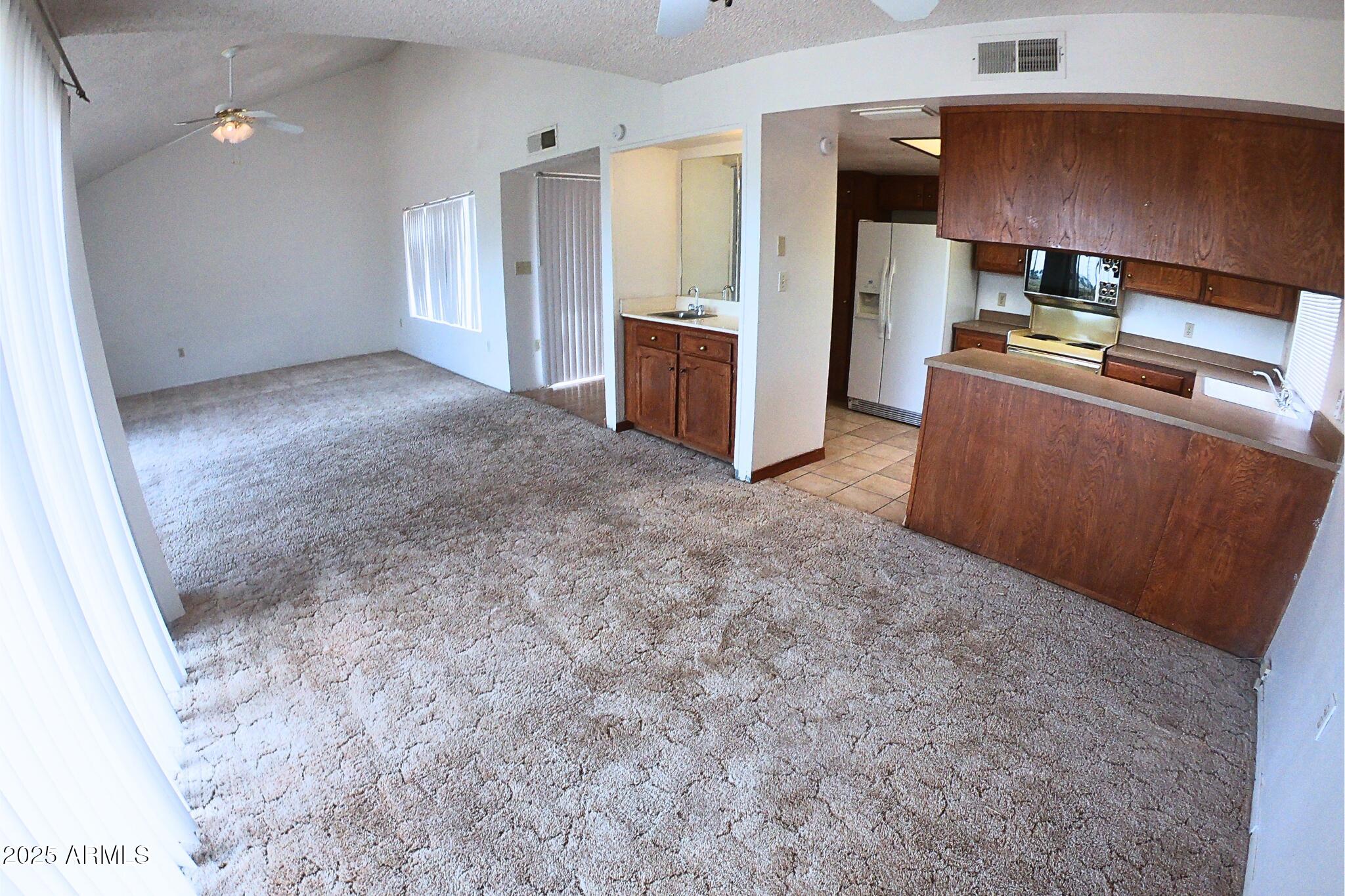 828 East Junction Street, Unit 832 Apache Junction, AZ 85119 - Photo 4 of 17 a view of a kitchen with refrigerator stove and wooden floor