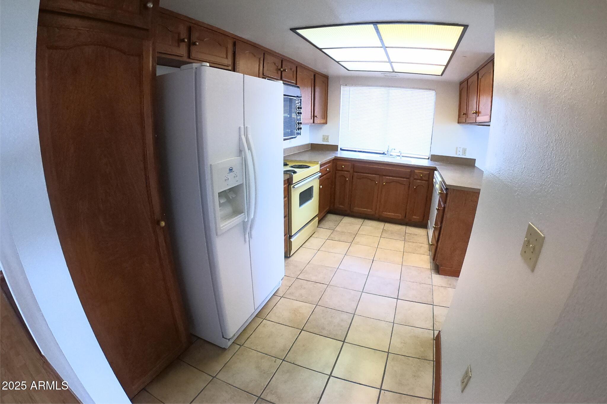828 East Junction Street, Unit 832 Apache Junction, AZ 85119 - Photo 6 of 17 a kitchen with a refrigerator a microwave and cabinets
