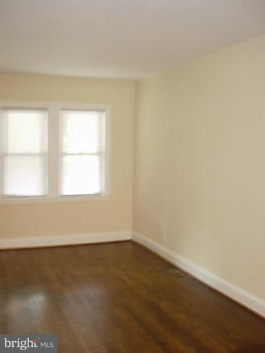 3718 Woodridge Road Baltimore, MD 21229 - Photo 5 of 18 an empty room with wooden floor and windows