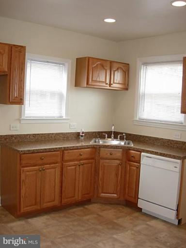 3718 Woodridge Road Baltimore, MD 21229 - Photo 9 of 18 a kitchen with stainless steel appliances granite countertop a sink and dishwasher a stove with wooden floor