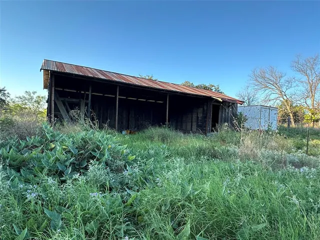 a view of house with large windows and plants