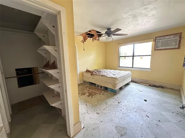 a view of a bedroom with a bed and a window