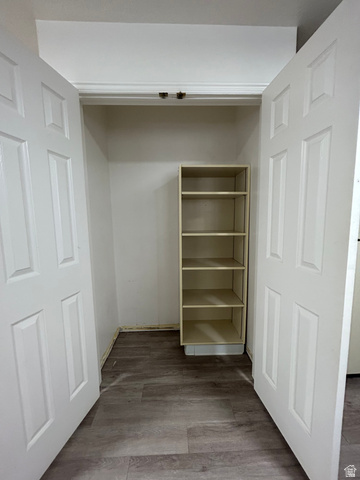 203 North Geneva Road, Unit 10 Provo, UT 84601 - Photo 15 of 16 Closet space with bifold doors, integrated shelving unit, wood-finish flooring, and white painted walls