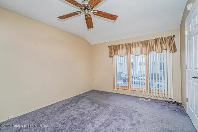 an empty room with windows and fan view