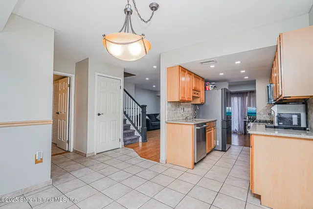 a kitchen with stainless steel appliances granite countertop a refrigerator a oven a sink and a refrigerator