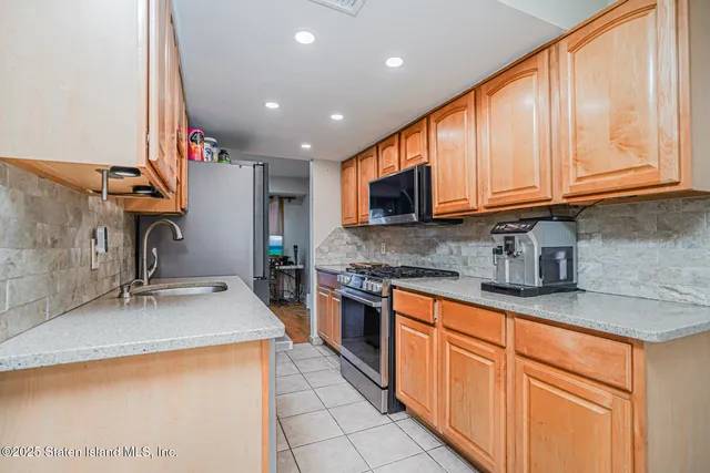 a kitchen with stainless steel appliances granite countertop a sink stove and cabinets