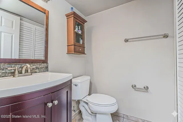 a bathroom with a sink and mirror with toilet