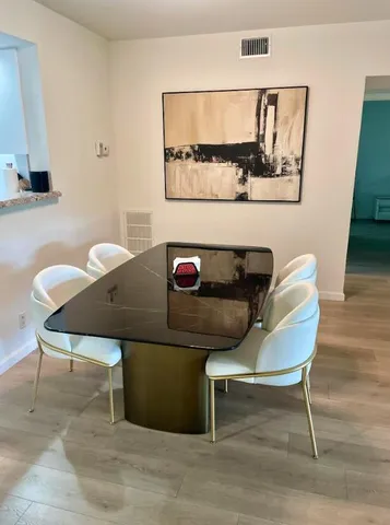 a view of a hallway with wooden floor and closet