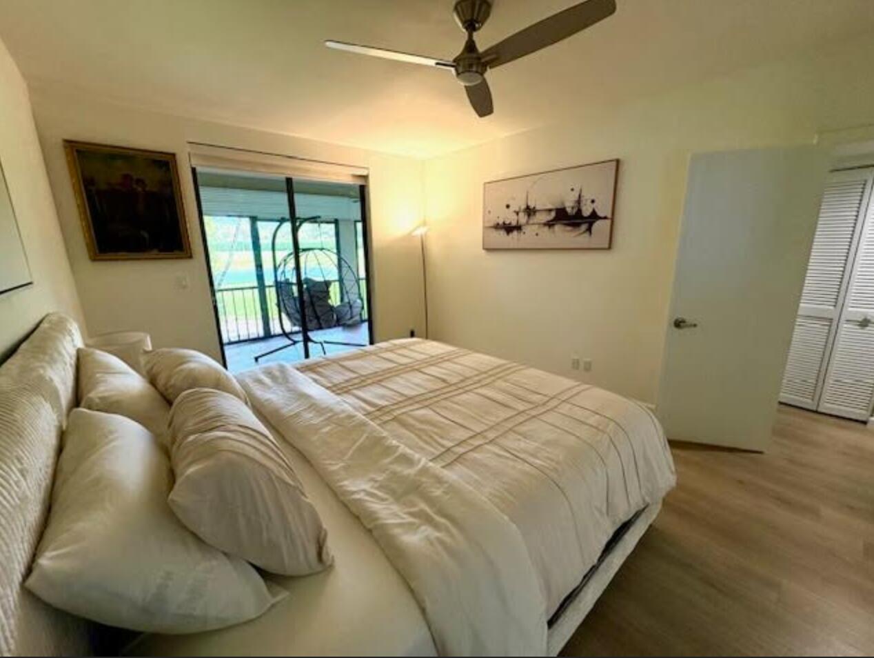 7744 La Mirada Drive Boca Raton, FL 33433 - Photo 15 of 33 a bed sitting in a bedroom next to a window with a flat screen tv