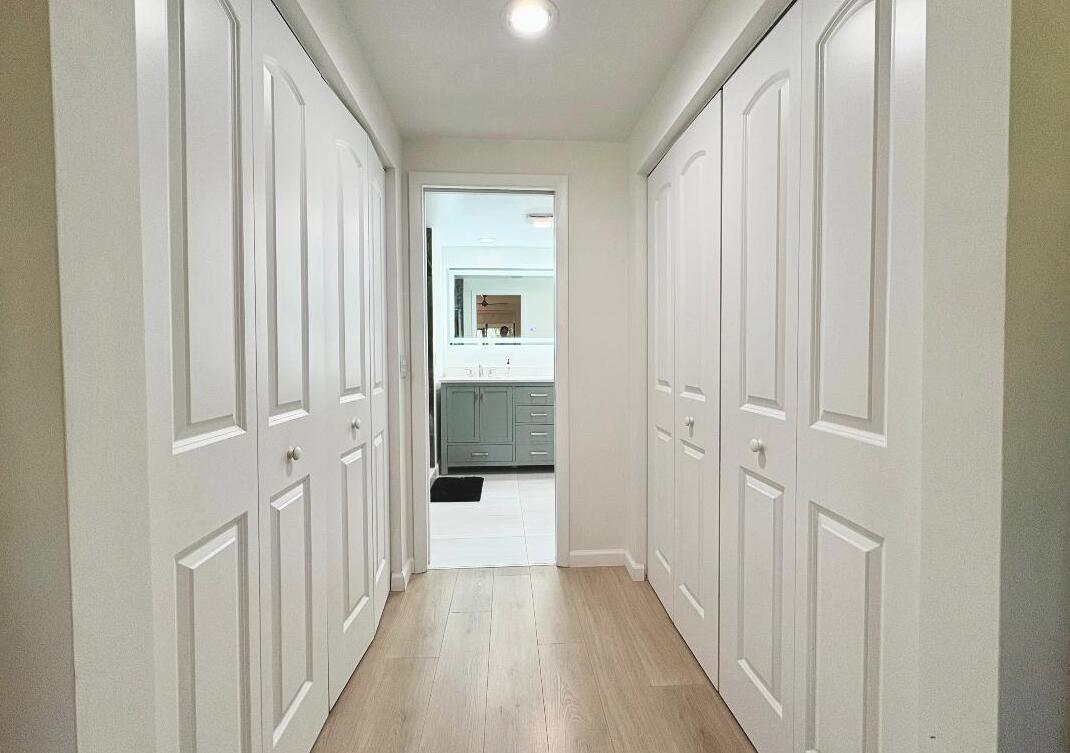 7744 La Mirada Drive Boca Raton, FL 33433 - Photo 16 of 33 a view of a hallway with wooden floor and closet