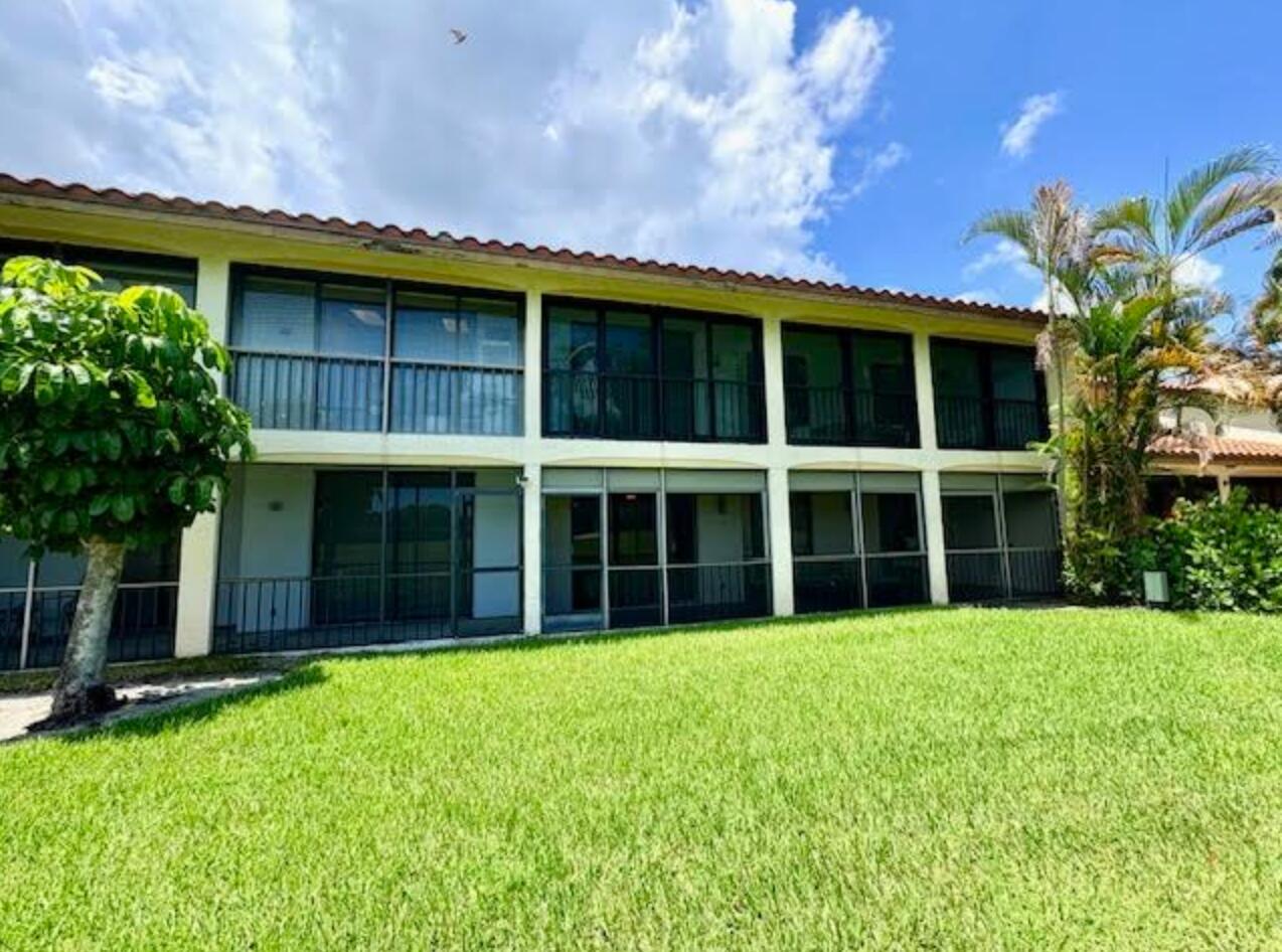 7744 La Mirada Drive Boca Raton, FL 33433 - Photo 29 of 33 a view of a large building with a large window and palm trees