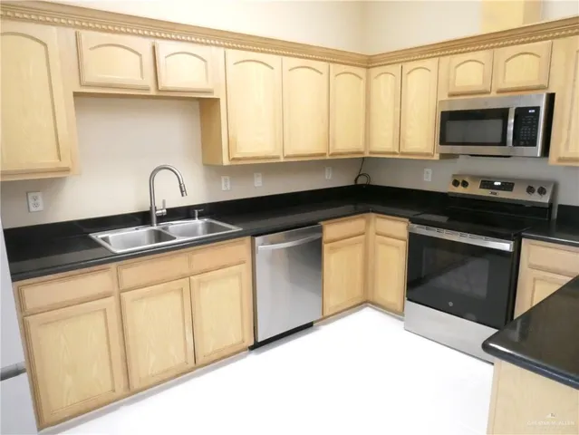 a kitchen with stainless steel appliances granite countertop a sink and a stove