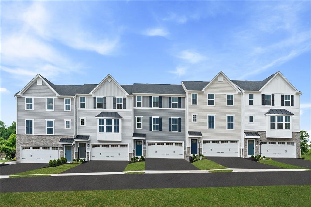 a front view of residential houses with yard and green space