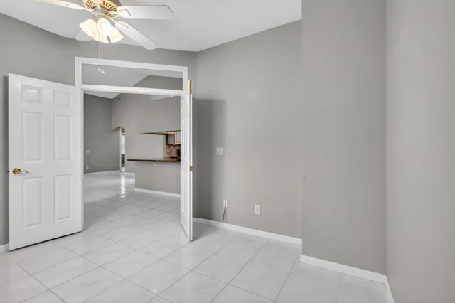 a view of a hallway with a chandelier and a bathroom