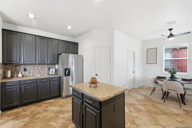 a kitchen with granite countertop a sink cabinets and stainless steel appliances
