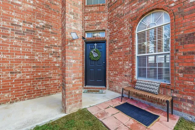 a brick building with a bench in front of door