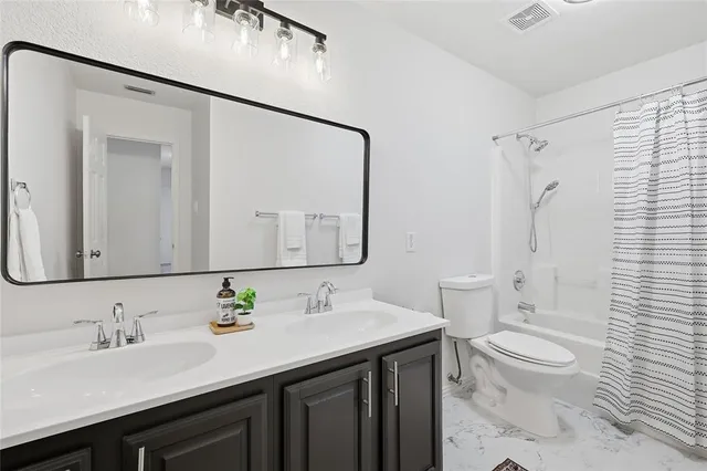 a bathroom with a granite countertop sink a toilet and a mirror