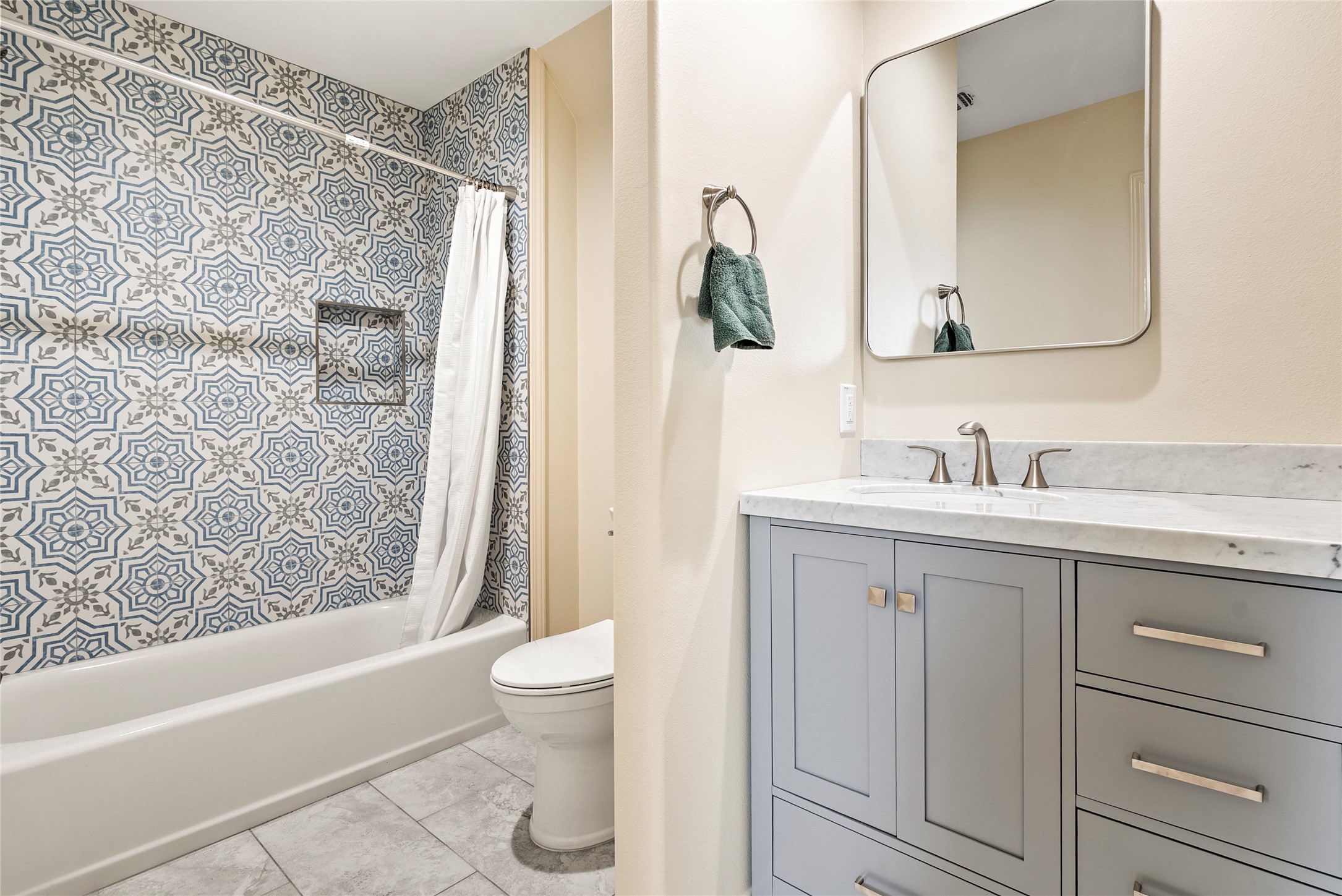 928 Upper Elgin River Road Elgin, TX 78621 - Photo 29 of 40 Bathroom featuring a patterned tile shower surround with integrated niche, a white tub, and light gray floor tiles.