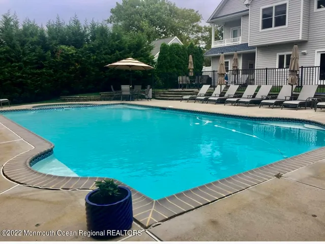 a swimming pool with outdoor seating yard and trees