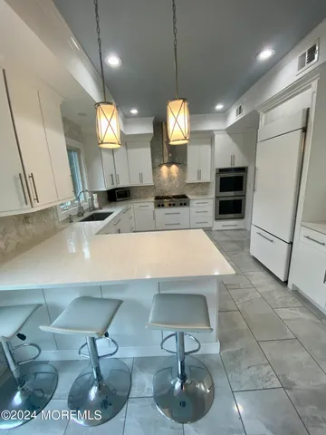 a kitchen with stainless steel appliances granite countertop a sink a stove and a wooden floors